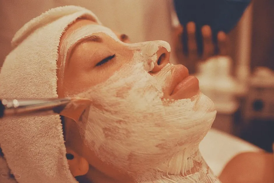 A calming spa facial treatment with a woman receiving a luxurious face mask application.